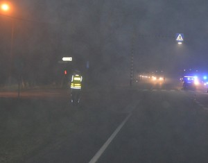 Policjant na miejscu wypadku kieruje ruchem pojazdów. Mgła - występuje bardzo ograniczona widoczność.