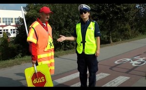 Policjantka stoi przy przejściu dla pieszych z Panem Stopkiem.