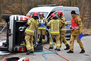 Strażacy ciężkim sprzętem rozcinają karoserię pojazdów, aby wyciągnąć poszkodowanych z rozbitego auta.
