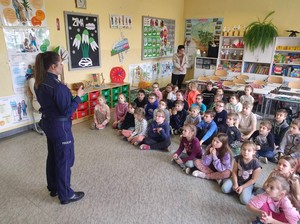 Policjantka prowadzi w sali zajęcia z dziećmi.