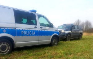 Radiowóz policyjny, a obok niego wóz patrolu saperskiego.