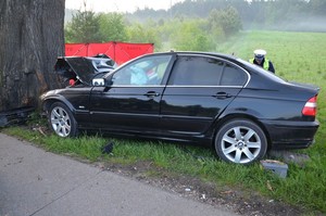 Policjant podczas sporządzania oględzin rozbitego bmw.