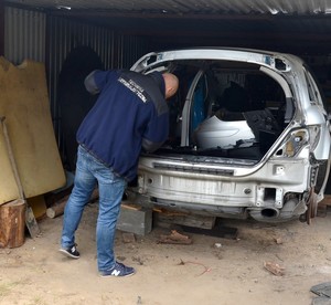 Technik prowadzi oględziny odzyskanego mercedesa.