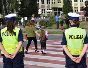 Policjantki stoją przed przejściem dla pieszych w pobliżu szkoły.
