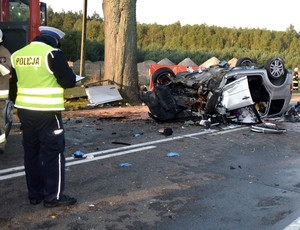 Policjant w czasie oględzin pojazdu na miejscu wypadku.