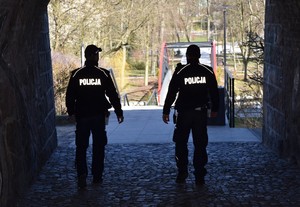 Policjanci podczas patrolu pieszego udają się w kierunku parku miejskiego. W tle kładka nad rzeką Wierzycą.
