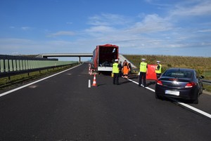 Policjanci na miejscu wypadku prowadzą oględziny rozbitych pojazdów.