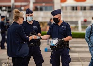 Policjanci rozdają maseczki.