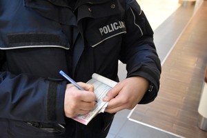 Policjant wypisuje mandat karny.