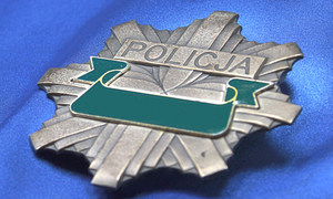Metalowa gwiazda policyjna na granatowym tle.