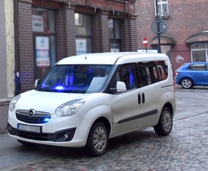 Nieoznakowany radiowóz policyjny zaparkowany z włączonymi światłami błyskowymi przed jedną ze starogardzkich kamienic.