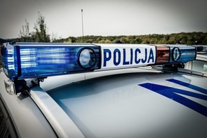 Dach policyjnego radiowozu z kogutem i napisem Policja.