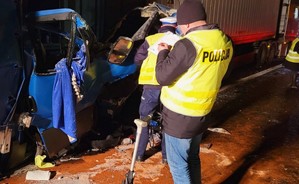 Policjant prowadzi oględziny uszkodzeń naczepy.