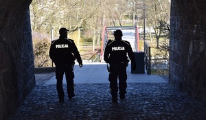 Policjanci podczas patrolu pieszego, wchodzą do parku miejskiego tunelem od strony ul. Chojnickiej.