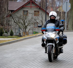 Policjant w czasie jazdy na motocyklu służbowym.