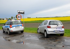 Policyjny radiowóz, a obok stoi zatrzymana podczas pościgu osobowa toyota.