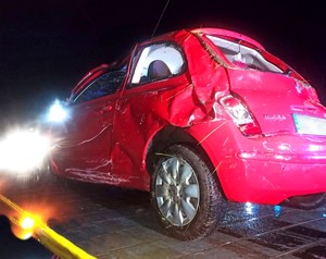 Rozbite auto stoi na lawecie. widok na tył i lewą stronę pojazdu.