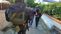Policjanci prowadzą zatrzymanego.