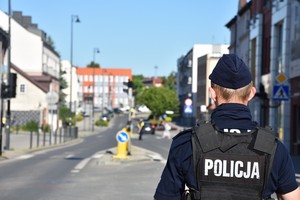 Policjant zwrócony plecami, który zabezpiecza wjazd na ulicę Kościuszki od strony ulicy Lubichowskiej.