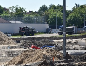 Ciężarówka patrolu saperskiego na placu budowy. Wokół wykopy i usypiska ziemi.