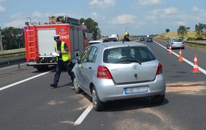 Policjant prowadzi oględziny rozbitej toyoty.