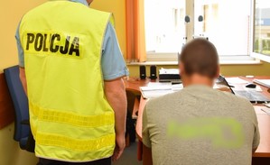 Policjant w trakcie wykonywania czynności z zatrzymanym mężczyzną.