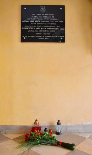 Kwiaty złożone przed tablicą pamiątkową w kościele w Pinczynie.