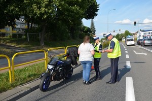 Policjanci prowadzą czynności procesowe związane z obsługą zdarzenia na miejscu wypadku.