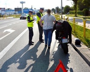 Policjanci prowadzą czynności procesowe związane z obsługą zdarzenia na miejscu wypadku.