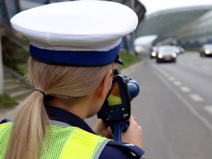 Policjantka mierzy prędkość pojazdów.