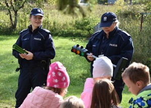Policjantki prezentują dzieciom model sygnalizatora świetlnego.