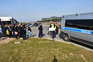 Policjanci wręczają opaski odblaskowe pieszym udającym się do pracy.