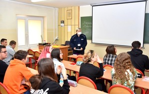 Policjantka w sali lekcyjnej prowadzi zajęcia nt. Handlu Ludźmi.