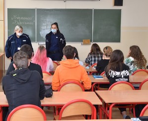 Policjantka w sali lekcyjnej prowadzi zajęcia nt. Handlu Ludźmi.