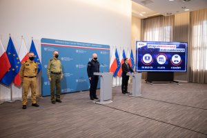 Zdjęcie z konferencji. Przedstawiciele służb podległych MSWiA przed mównicą.