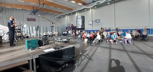 Dzielnicowy ze Skarszew przemawia ze sceny do seniorów, uczestników imprezy.