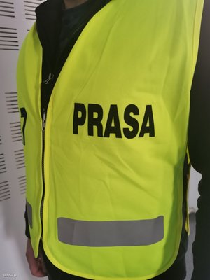 Przykład kamizelki odblaskowej z czarnym napisem PRASA.