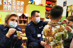 Policjanci wręczają dzieciom odblaski.