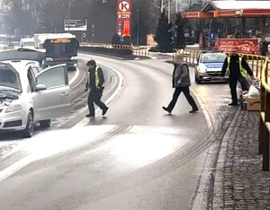 Policjanci wynoszą z auta przedmioty, które w wyniku akcji gaśniczej mogłyby uleć zniszczeniu.