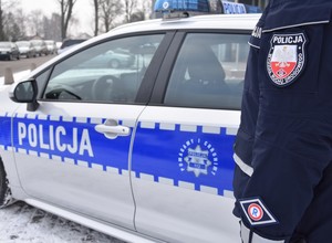 Napis policja na lewym boku oznakowanego radiowozu.