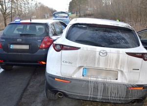 Na pierwszym planie widać tył odzyskanej mazdy, a po lewej stronie nieoznakowany radiowóz, który blokuje możliwość ucieczki.