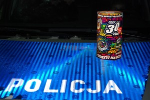 Puszka WOŚP na masce oznakowanego radiowozu. Poniżej odblaskowy napis POLICJA.