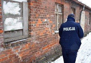 Policjant kontroluje pustostany.