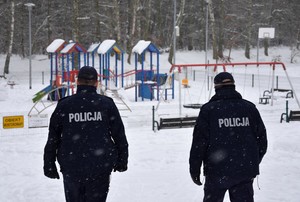 Policjanci kontrolują teren placu zabaw.