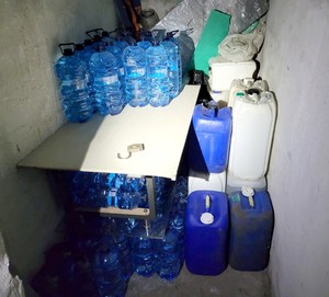 Piwnica, w której na ziemi stoją plastikowe pojemniki ze spirytusem bez polskich znaków akcyzy.