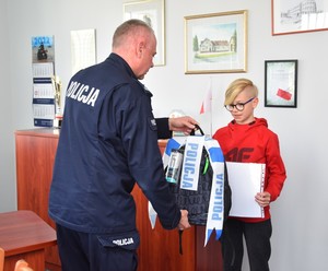 inspektor Bogusław Ziemba Komendant Powiatowy Policji wręcza 10-latkowi nagrodę za wzorowe zachowanie.