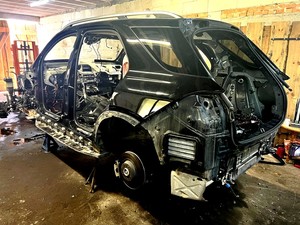 Karoseria całkowicie rozkręconego mercedesa stojąca w garażu. Widok z tyłu.