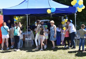 Widok na policyjny namiot przy którym stoją uczestnicy festynu.