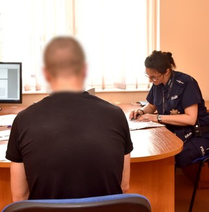 Policjantka podczas przesłuchania podejrzanego.
