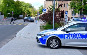 Policyjny radiowóz zaparkowany w pobliżu przejścia dla pieszych.